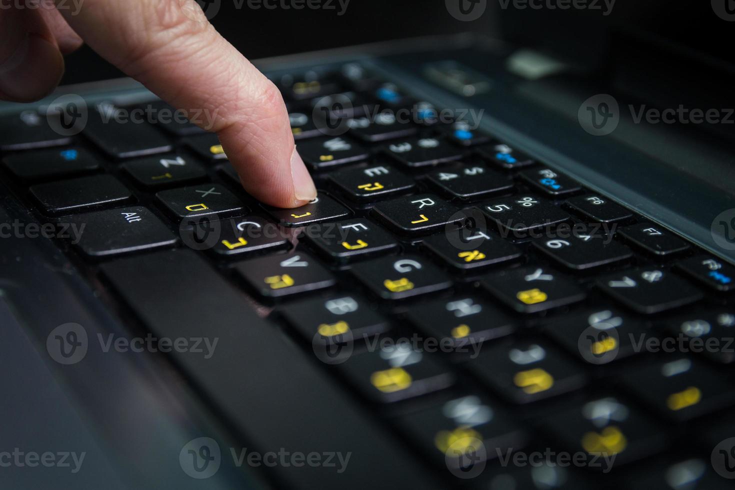 man typt op een toetsenbord met letters in het hebreeuws en engels foto