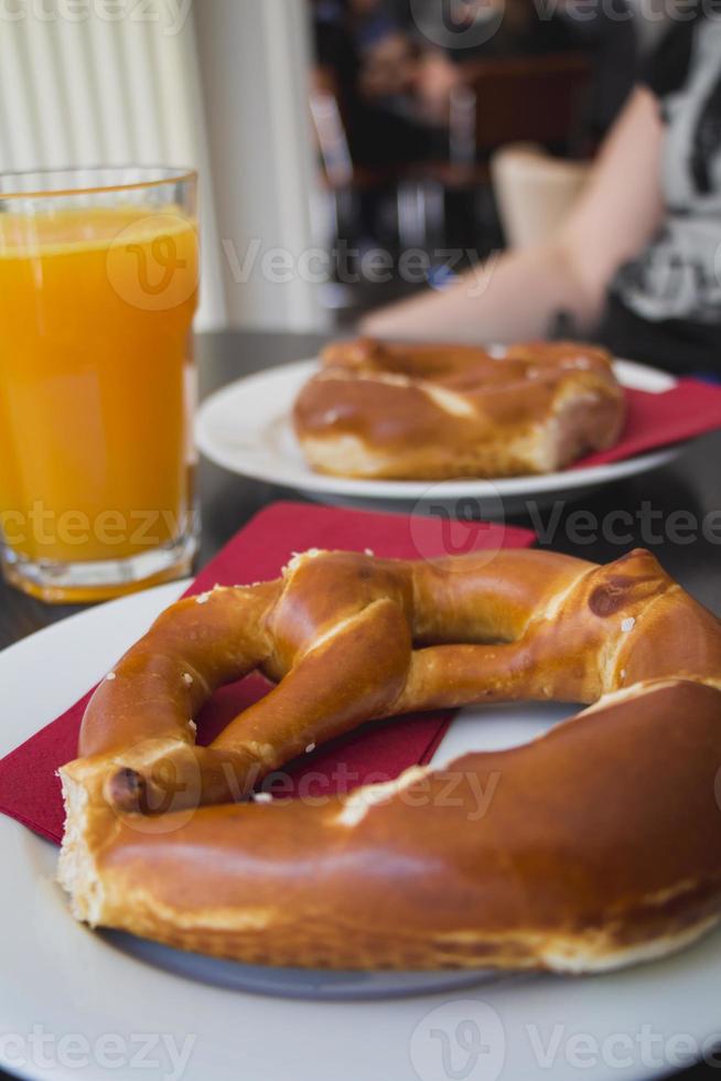 krakelingbrood op witte plaat en jus d'orange op houten tafel foto