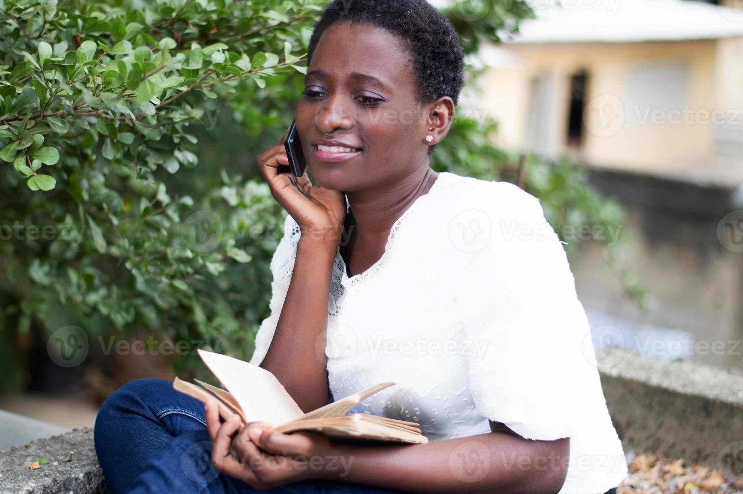 jonge vrouw belt met een boek in de hand foto
