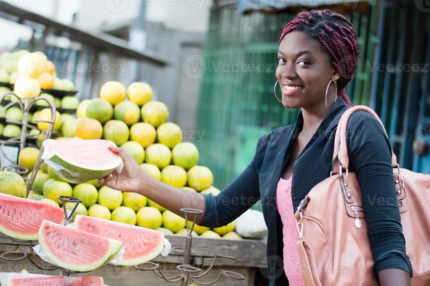 lachende jonge vrouw grijpt een plakje rijp fruit. foto