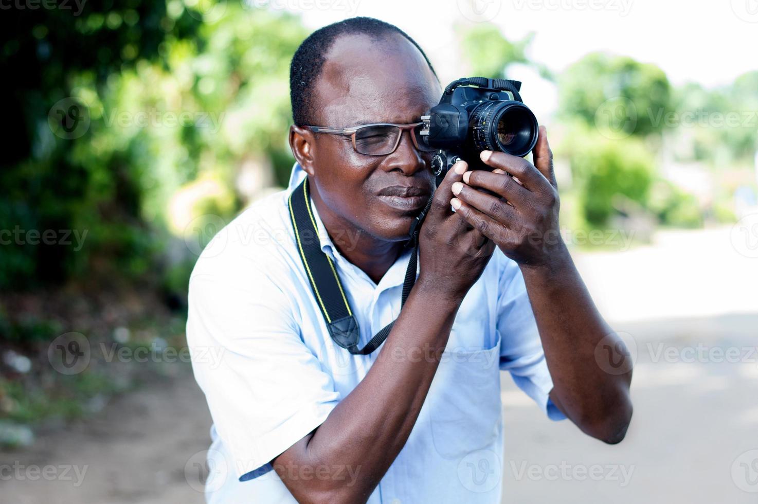 jonge man die foto's maakt met een digitale camera in campagne foto