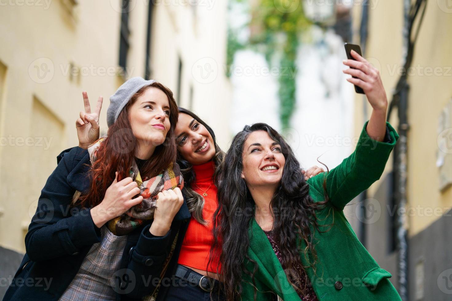 groep van drie gelukkige vrouw die samen buiten loopt foto