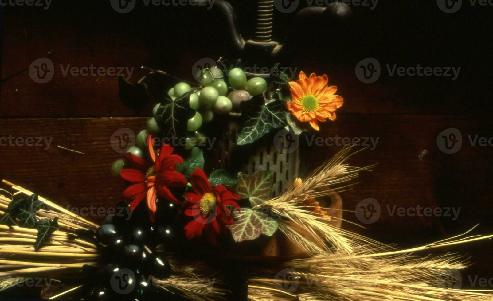 een vaas met bloemen en een bundel van tarwe foto