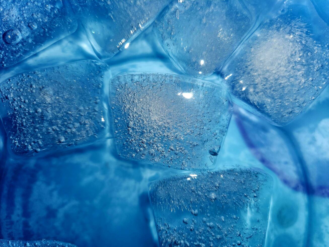 ijs kubussen geïsoleerd Aan blauw achtergrond foto