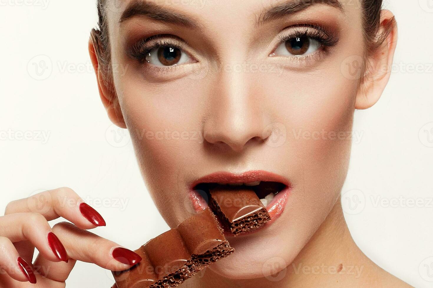 lief glimlachen tiener- meisje aan het eten chocola foto