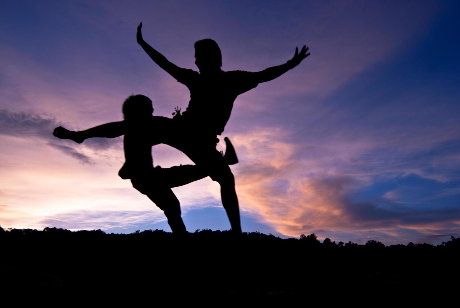 silhouet gelukkig springen tegen mooi in zonsondergang. vrijheid, plezier concept foto