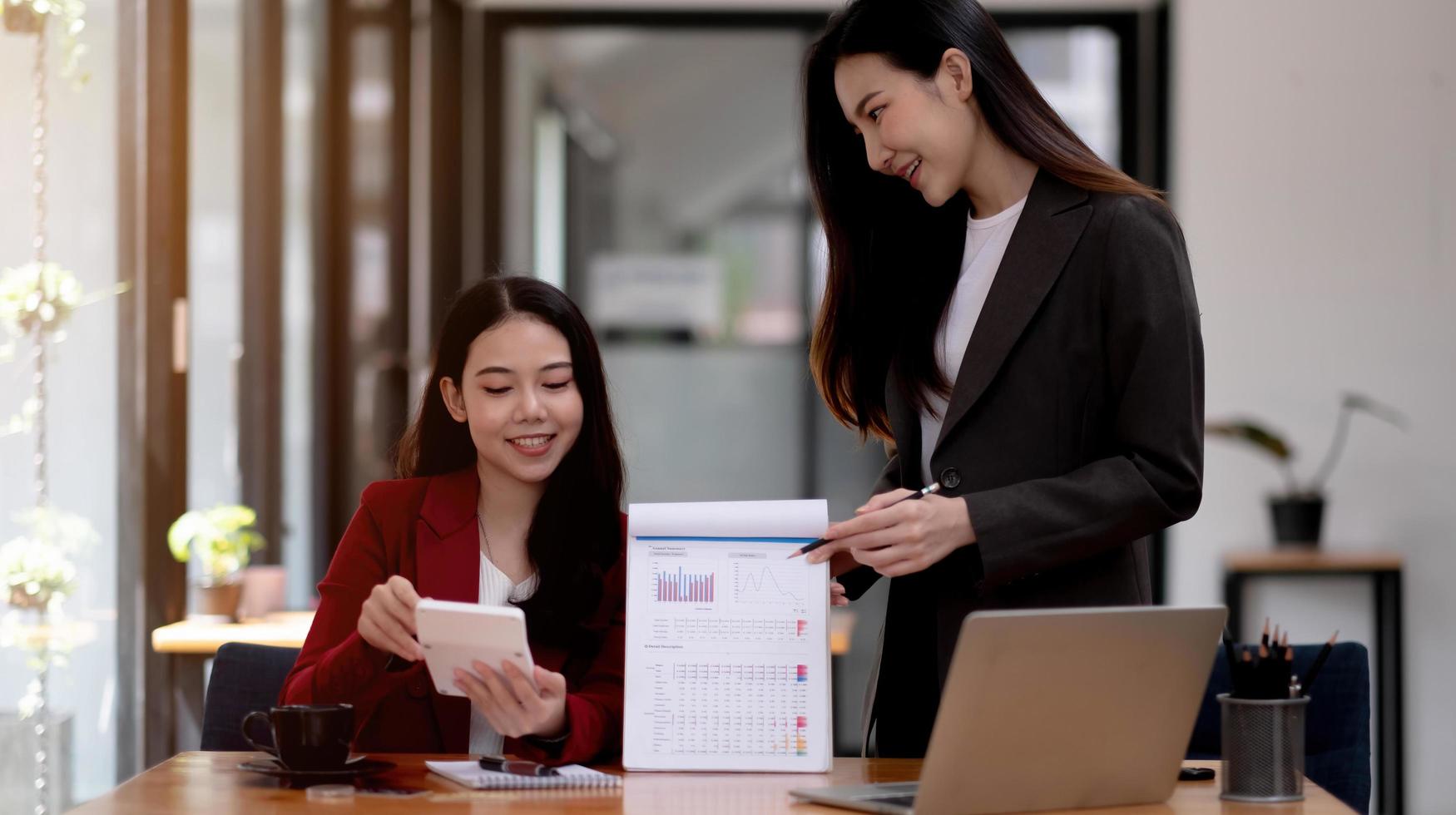 zaken en partnerschap bespreken het gebruik van een rekenmachine om de balans jaarlijks te herzien met een pen en het gebruik van een laptop om het budget te berekenen. audit integriteit vóór investeringsconcept. foto