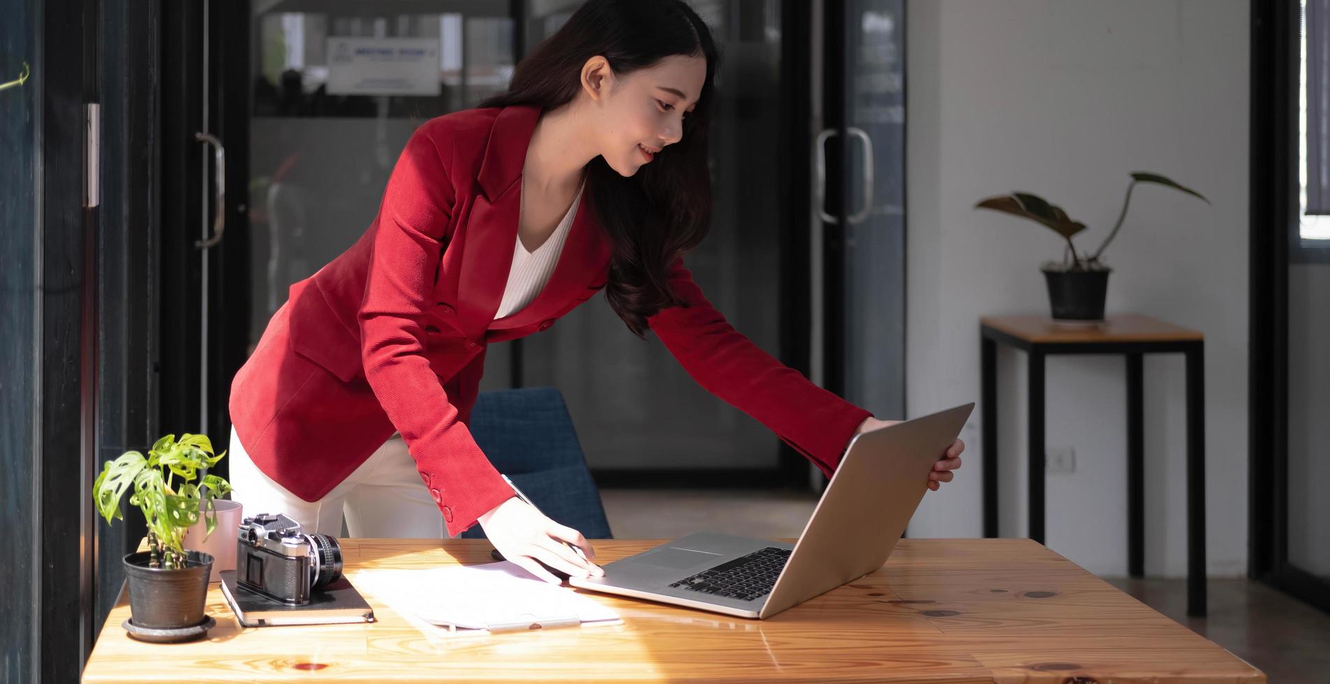 portret van aantrekkelijke jonge aziatische vrouw die met laptopcomputer werkt foto