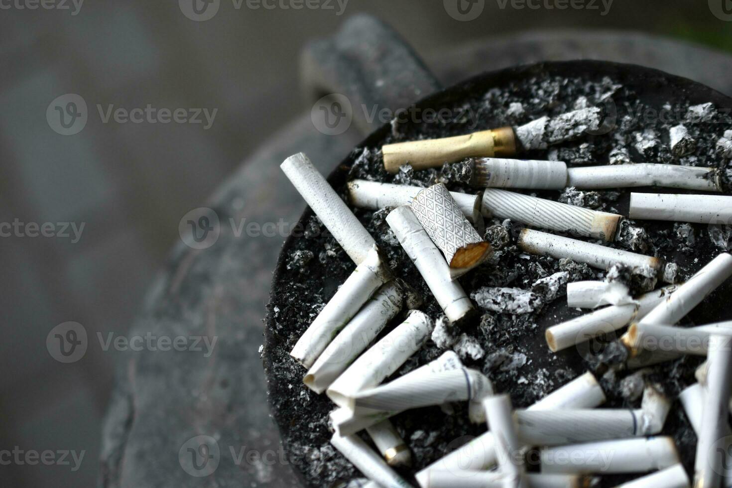 een asbakje voor sigaret peuken Aan de straat. gerookt sigaretten in de afval. foto