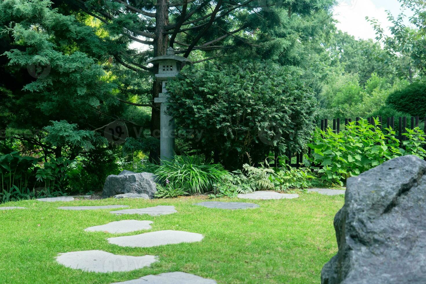 Japans tuin landschap met steen lantaarn onder pijnboom boom foto