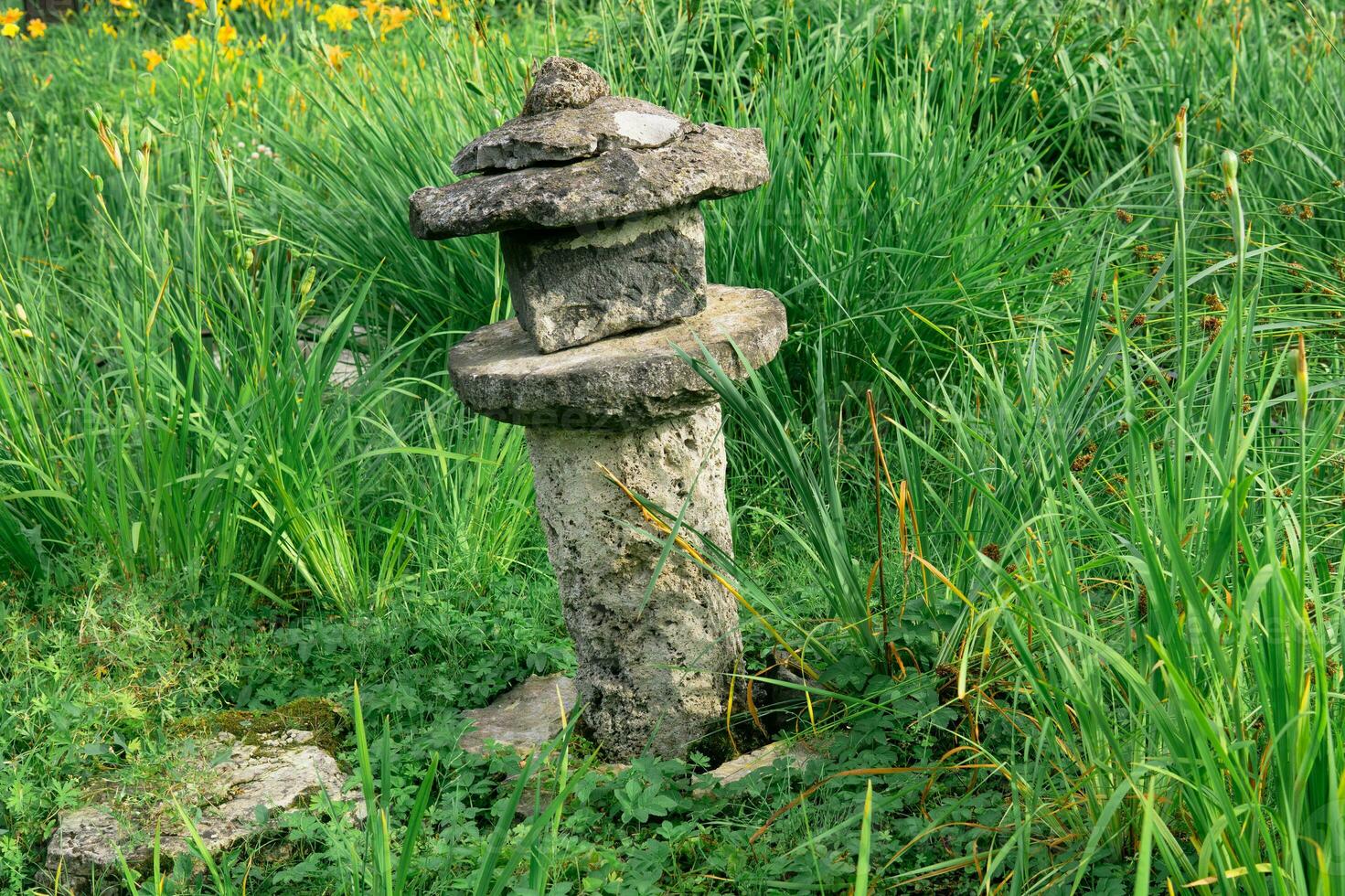 oud steen lantaarn tussen gras in een Japans tuin foto
