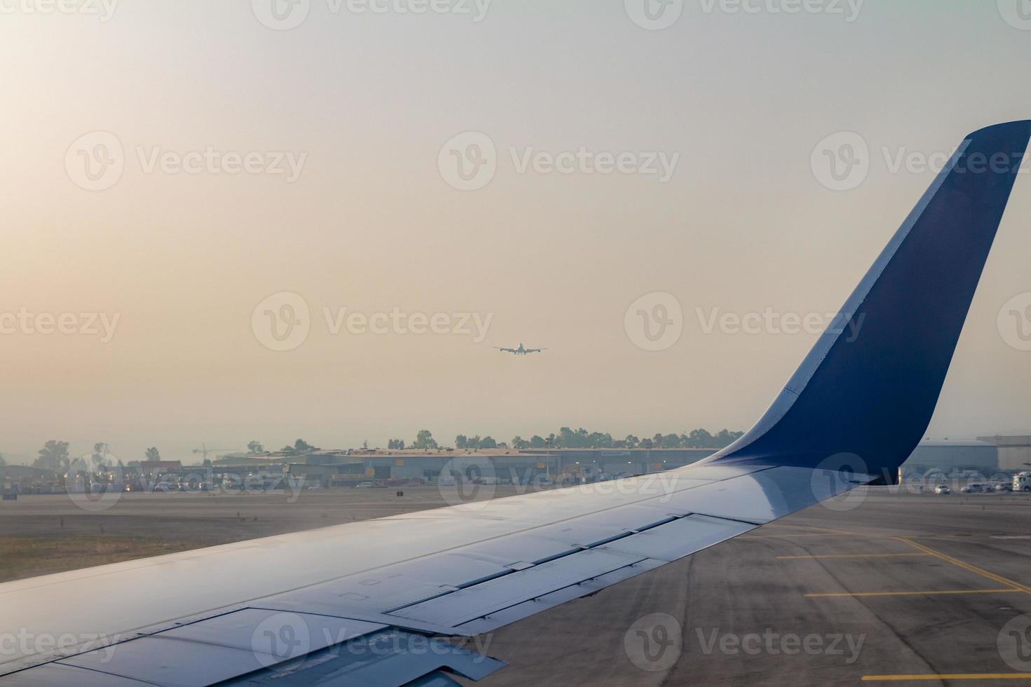 vliegtuigvleugel op de landingsbaan op de luchthaven ben gurion bij zonsopgang foto