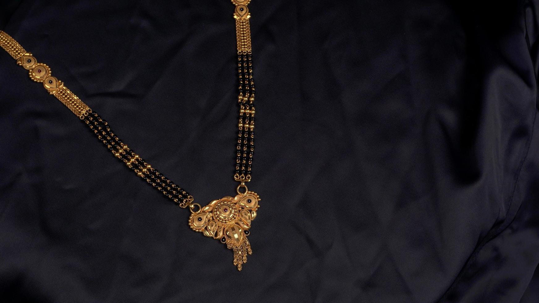 mangalsutra of gouden ketting om te dragen door een getrouwde hindoe vrouwen, gearrangeerd met mooie achtergrond. Indiase traditionele sieraden. foto