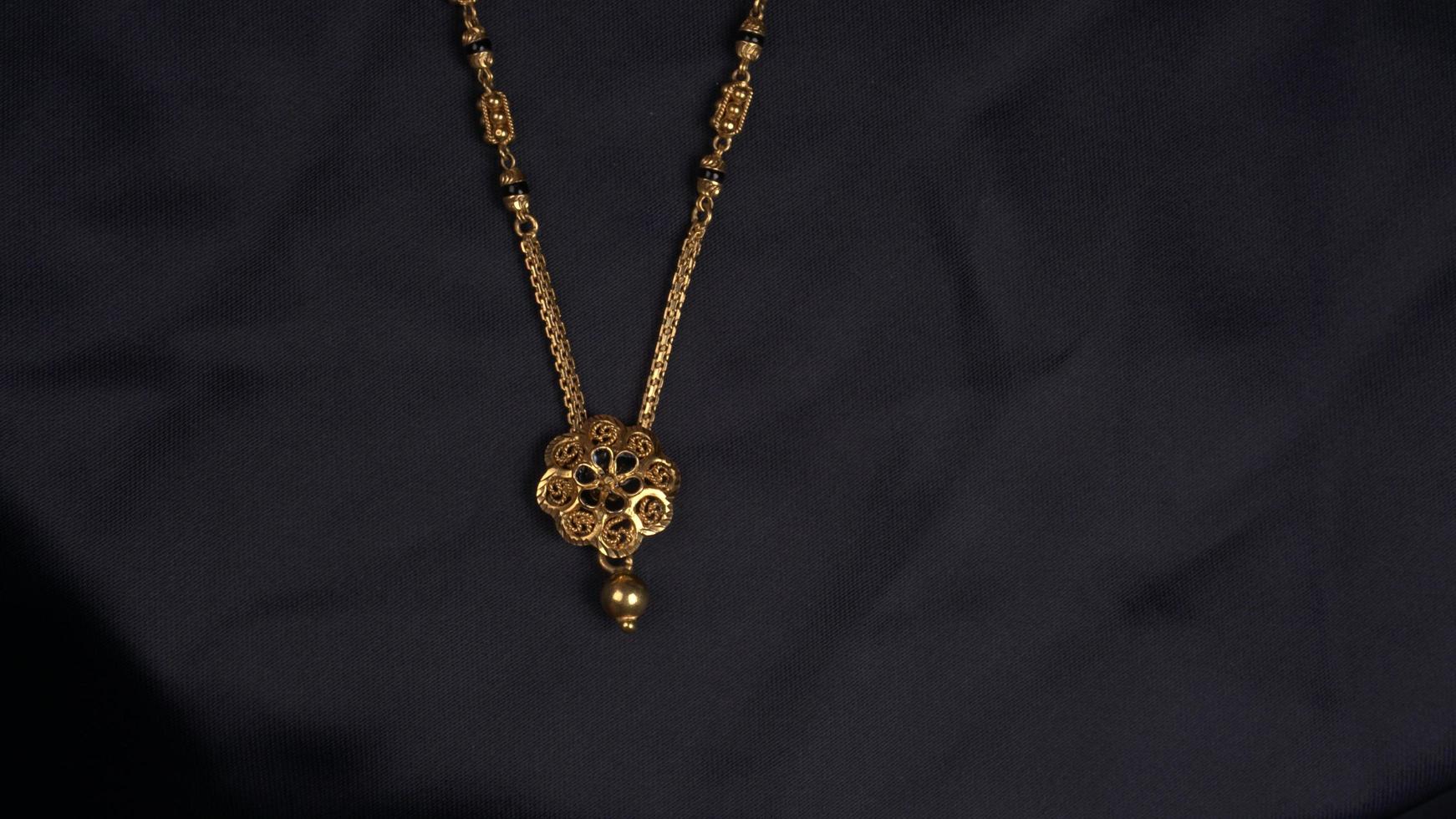 mangalsutra of gouden ketting om te dragen door een getrouwde hindoe vrouwen, gearrangeerd met mooie achtergrond. Indiase traditionele sieraden. foto