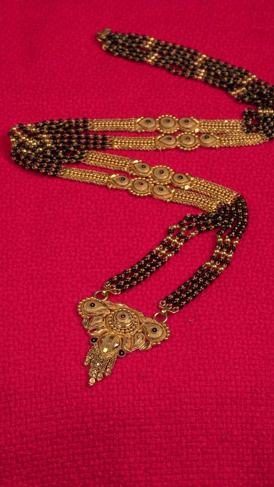 mangalsutra of gouden ketting om te dragen door een getrouwde hindoe vrouwen, gearrangeerd met mooie achtergrond. Indiase traditionele sieraden. foto