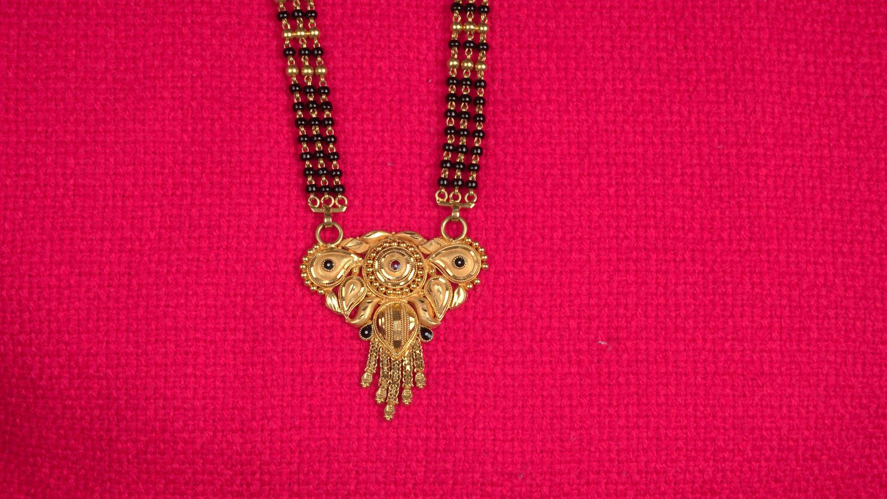 mangalsutra of gouden ketting om te dragen door een getrouwde hindoe vrouwen, gearrangeerd met mooie achtergrond. Indiase traditionele sieraden. foto