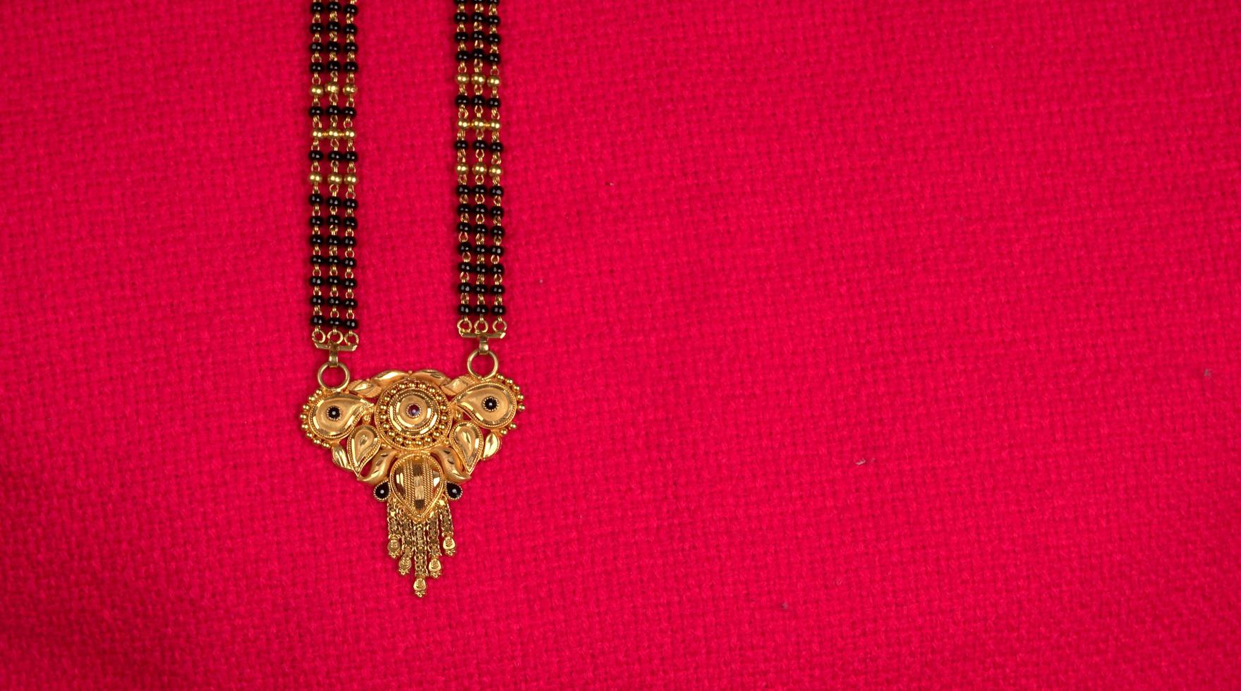 mangalsutra of gouden ketting om te dragen door een getrouwde hindoe vrouwen, gearrangeerd met mooie achtergrond. Indiase traditionele sieraden. foto