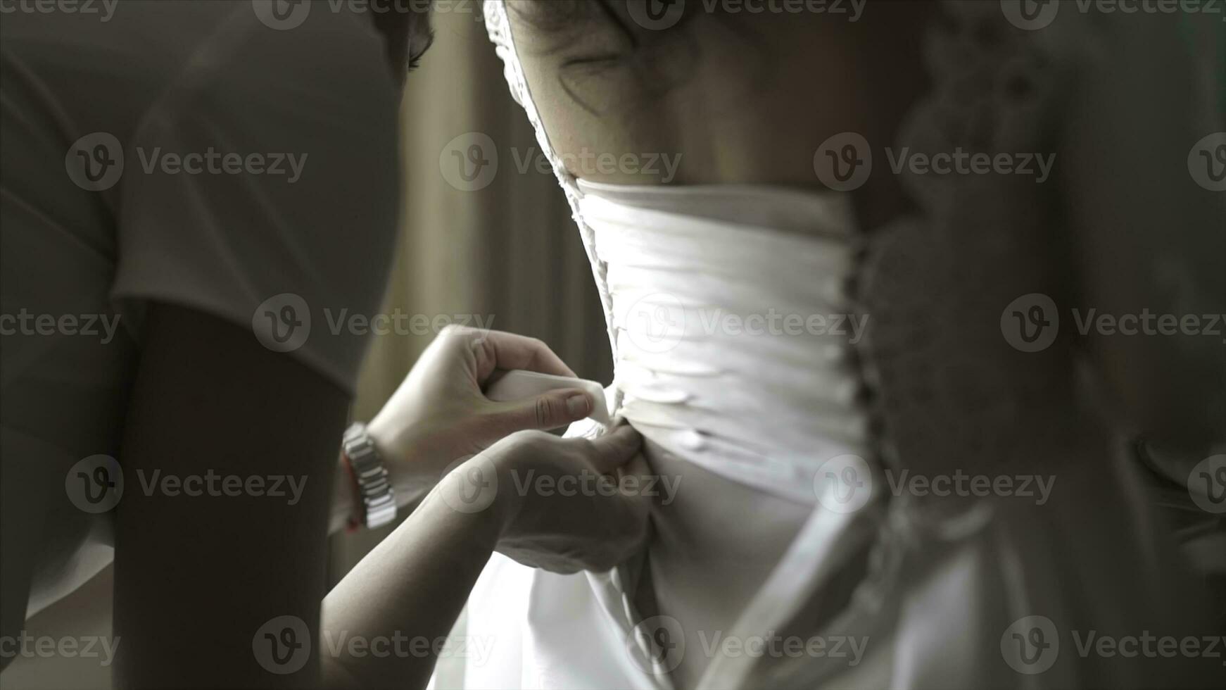 elegant mooi bruidsmeisjes helpen prachtig brunette bruid in wit jurk krijgen klaar voor bruiloft, ochtend- voorbereidende werkzaamheden, vrouw zetten Aan jurk. mam en bruidsmeisje, helpen naar jurk een bruiloft jurk foto