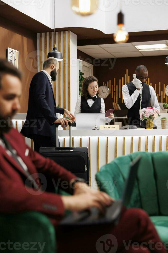 op reis voor werk, zakenman controle in Bij hotel ontvangst bureau met paspoort voor kamer reservering bevestiging. gast geven ID kaart documenten naar voorkant bureau personeel, identificatie Diensten. foto