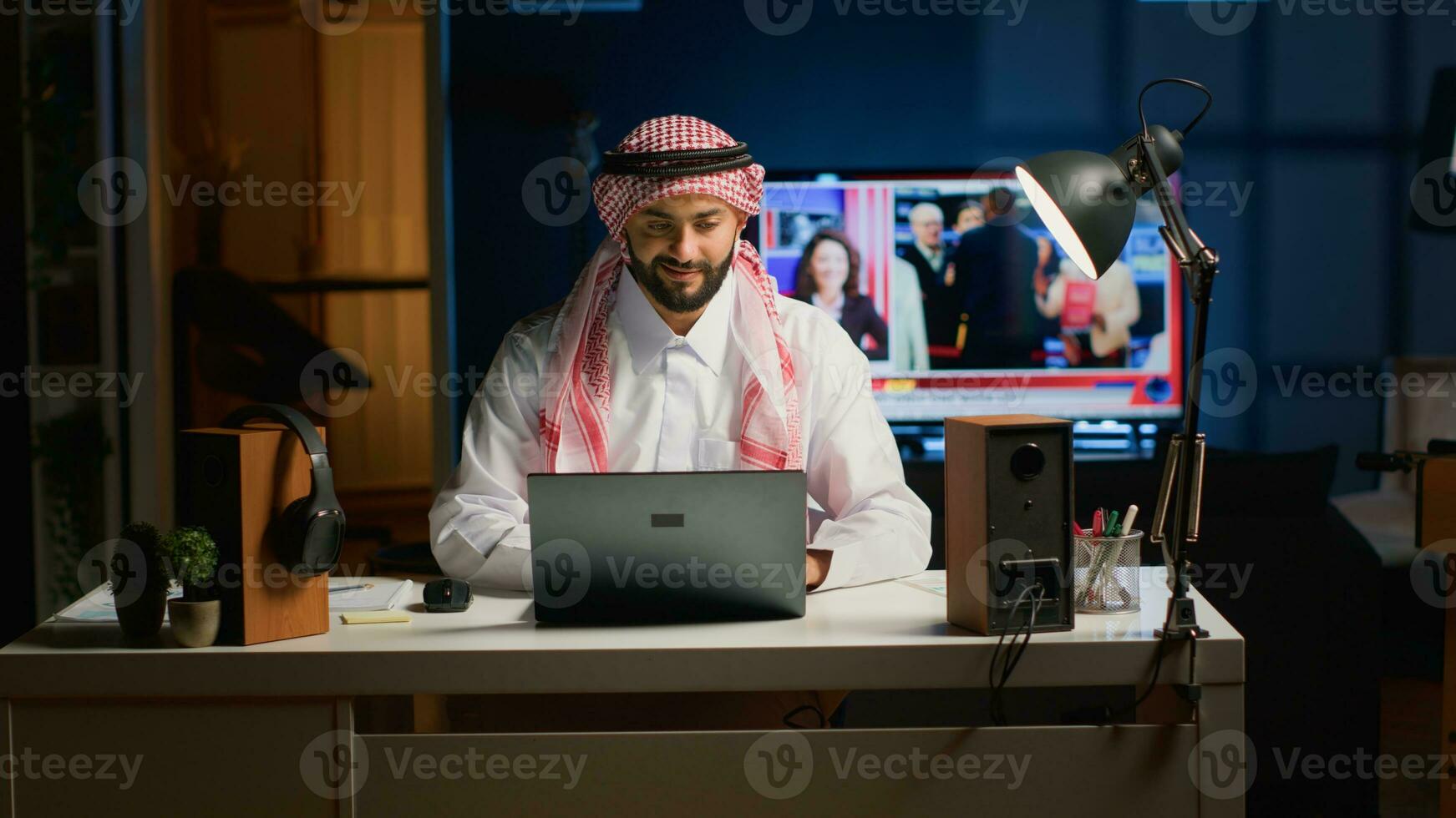 Arabisch zakenman typen Aan laptop, surfing de netto terwijl blijven Bij huis. moslim Mens converseren door e-mail in professioneel bedrijf omgeving, gefocust Aan oplossen divers taken foto