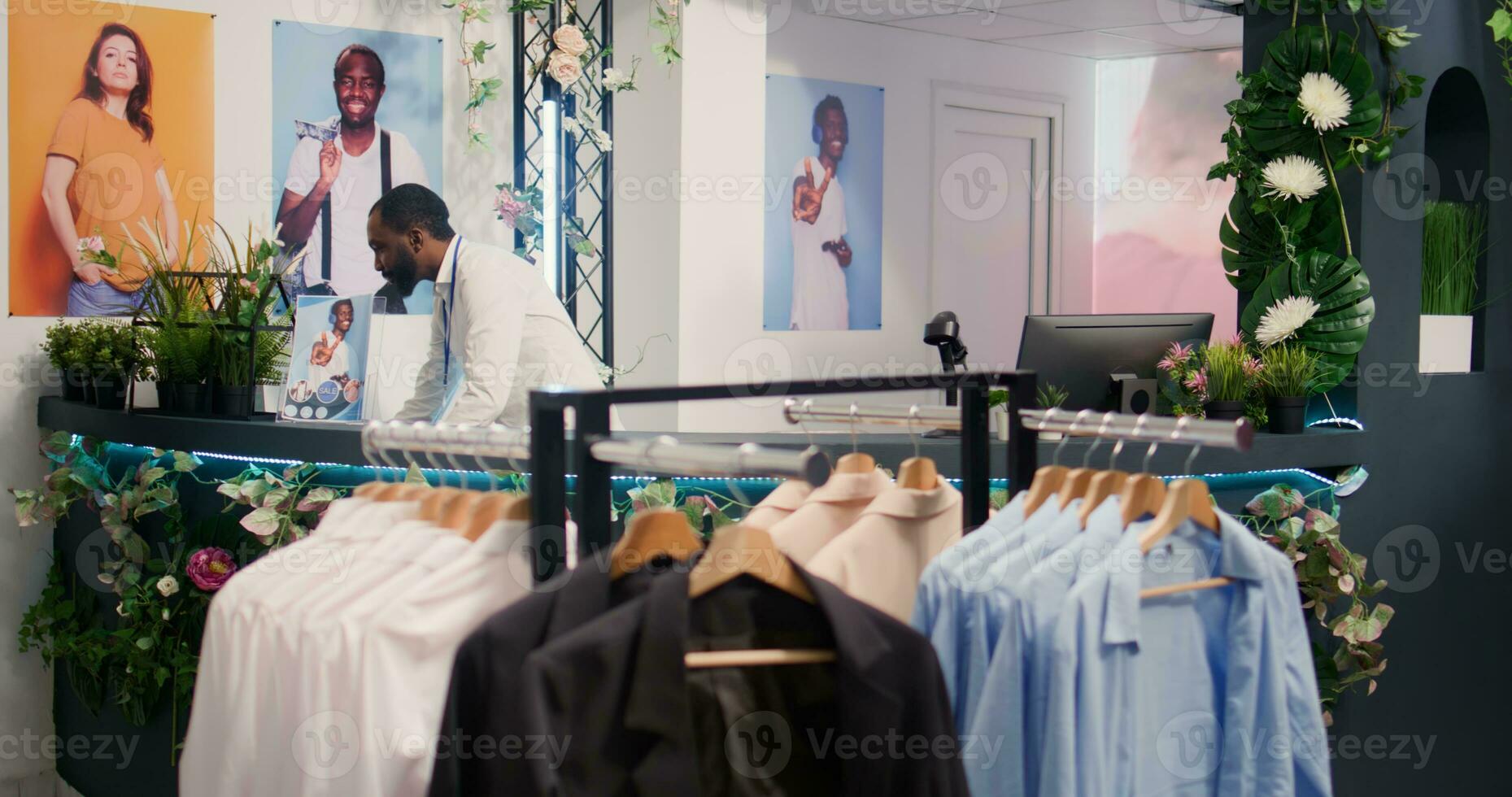 kleinhandel assistent in elegant mode winkel aan het wachten naar te ontvangen partij van nieuw handelswaar, toeschrijven gegevens Aan digitaal apparaat. arbeider in kleding op te slaan in afwachting levering van kledingstukken van nieuw verzameling foto