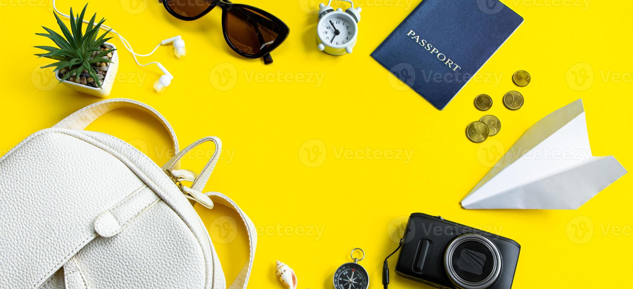 zomer reizen concept. paspoort, geld, zonnebril en een camera op een gele achtergrond. bannerformaat foto