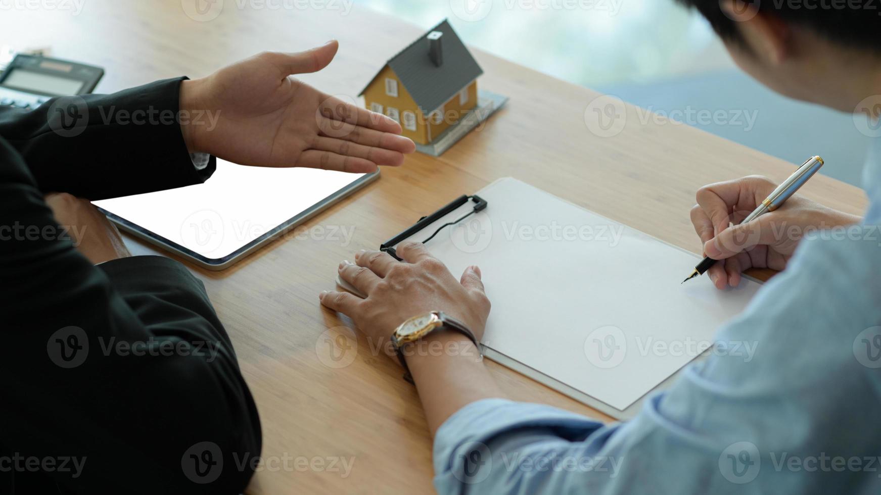 verzekeringsagenten introduceren klanten om onroerendgoedverzekeringscontracten te ondertekenen. foto