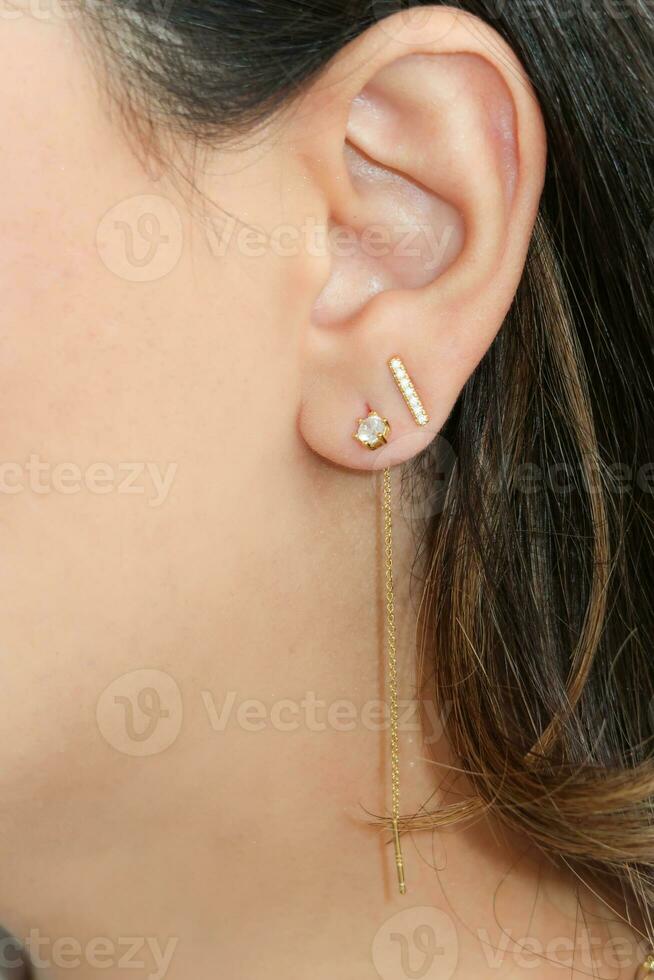vrouw vervelend mooi bungelend en stud oorbellen met zirkonia. foto