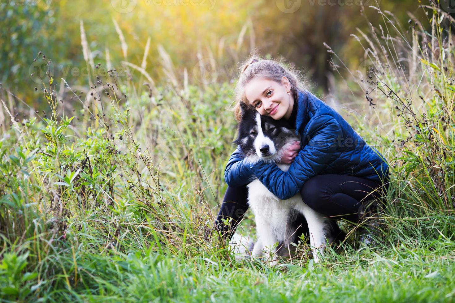 meisje zit knuffelen met haar hond foto