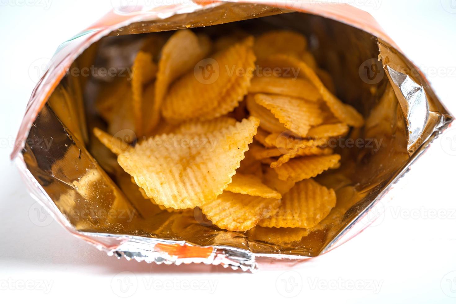 chips, heerlijke bbq-kruiden pittig voor crips, dunne plak gefrituurde snack fastfood in open zak. foto
