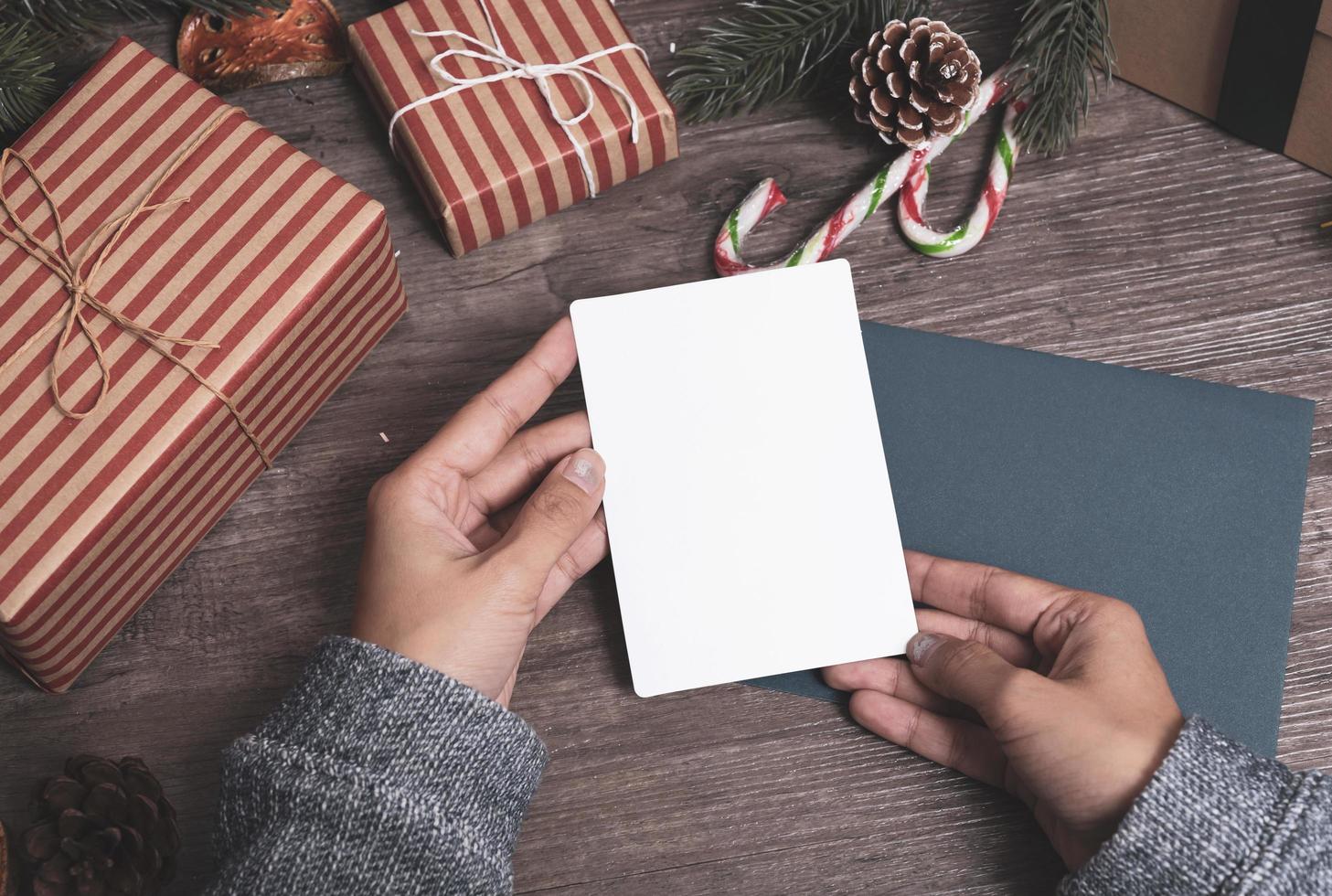 mockup tag papieren kaart met kerstversiering op houten tafel achtergrond. foto