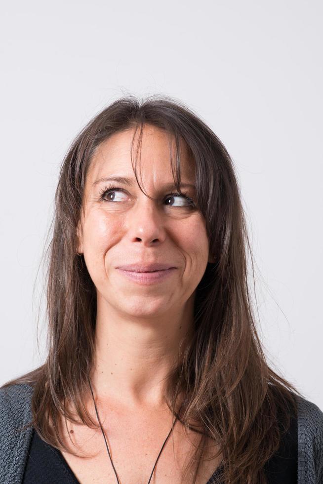 headshot van een mediterrane vrouw van 30-40 jaar met een grappig gezicht naar de camera die naar rechts van haar kijkt foto