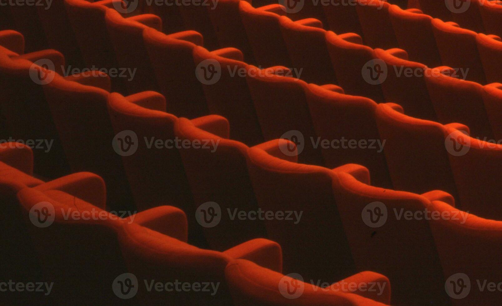 rijen van oranje stoelen in een auditorium foto