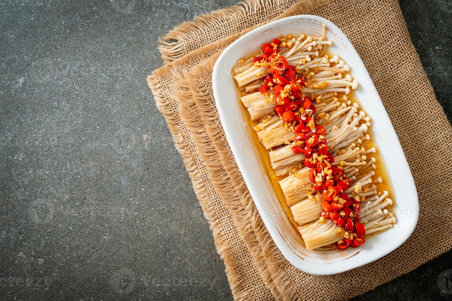 gestoomde gouden naaldpaddestoel of enokitake met sojasaus, chili en knoflook foto