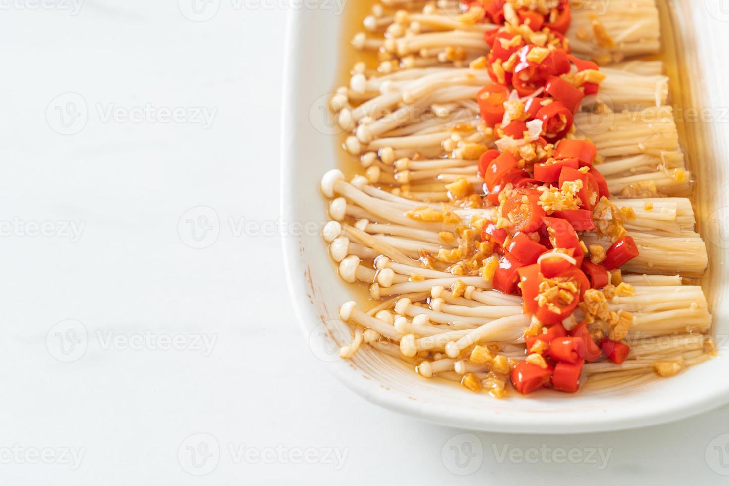 gestoomde gouden naaldpaddestoel of enokitake met sojasaus, chili en knoflook foto