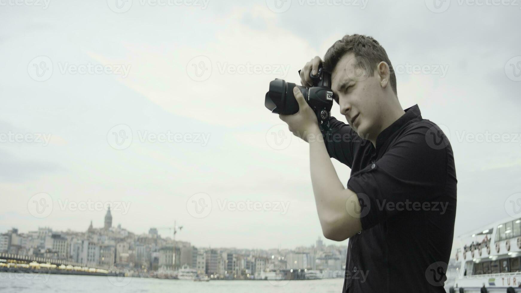 fotograaf schiet architectuur Aan camera. actie. professioneel mannetje fotograaf wandelingen in de omgeving van stad en schiet landschappen. Mens wandelingen in de omgeving van stad met professioneel camera foto