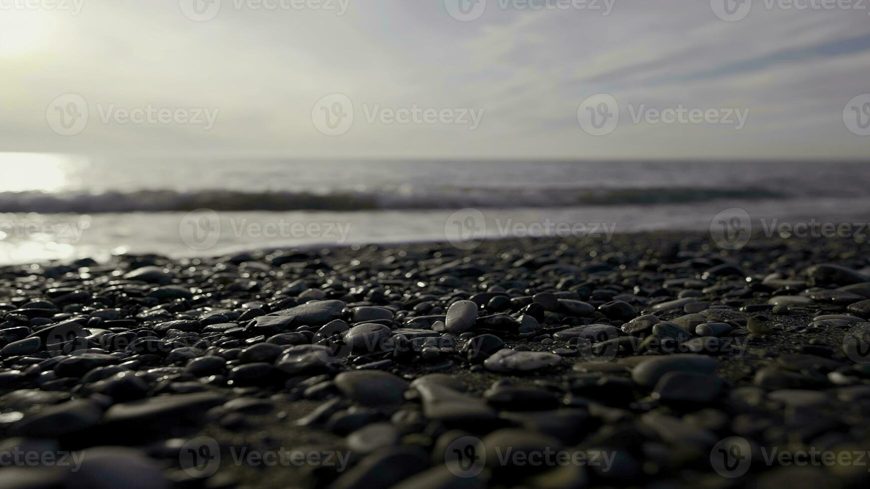 kiezelsteen strand met klein steentjes en zee golven. actie. zee oppervlakte Aan de wild kiezelsteen strand, stil avond Aan de adriatisch kust. foto