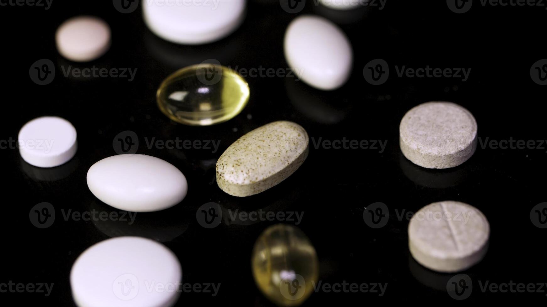 pillen draaien. stapel van meerdere geneesmiddelen. wit tablets met pillen Aan zwart achtergrond. geopend geneeskunde capsule pil foto