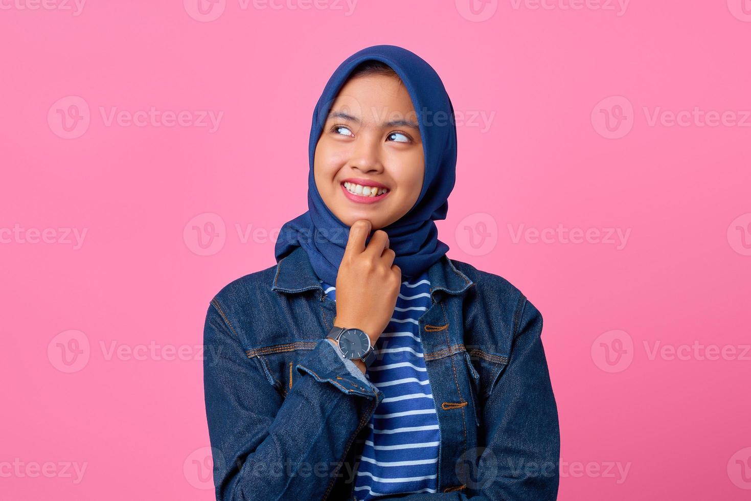 portret van glimlachende jonge aziatische vrouw met hand op kin en kijkend naar de zijkant? foto