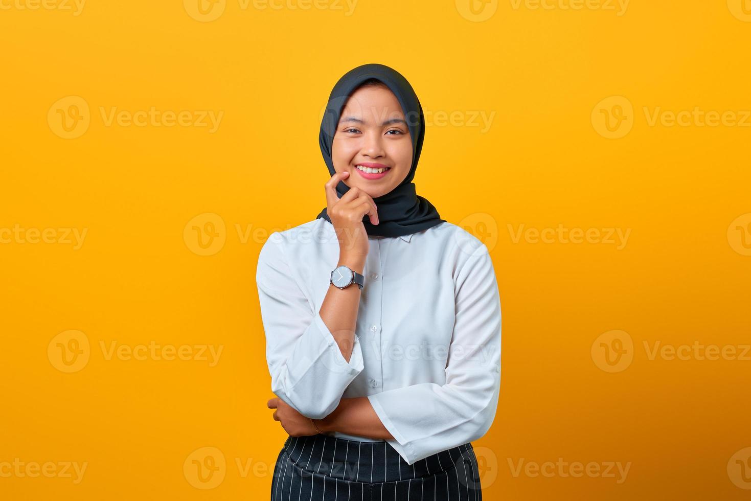 glimlachende jonge Aziatische vrouw met een aangename verschijning op gele achtergrond foto