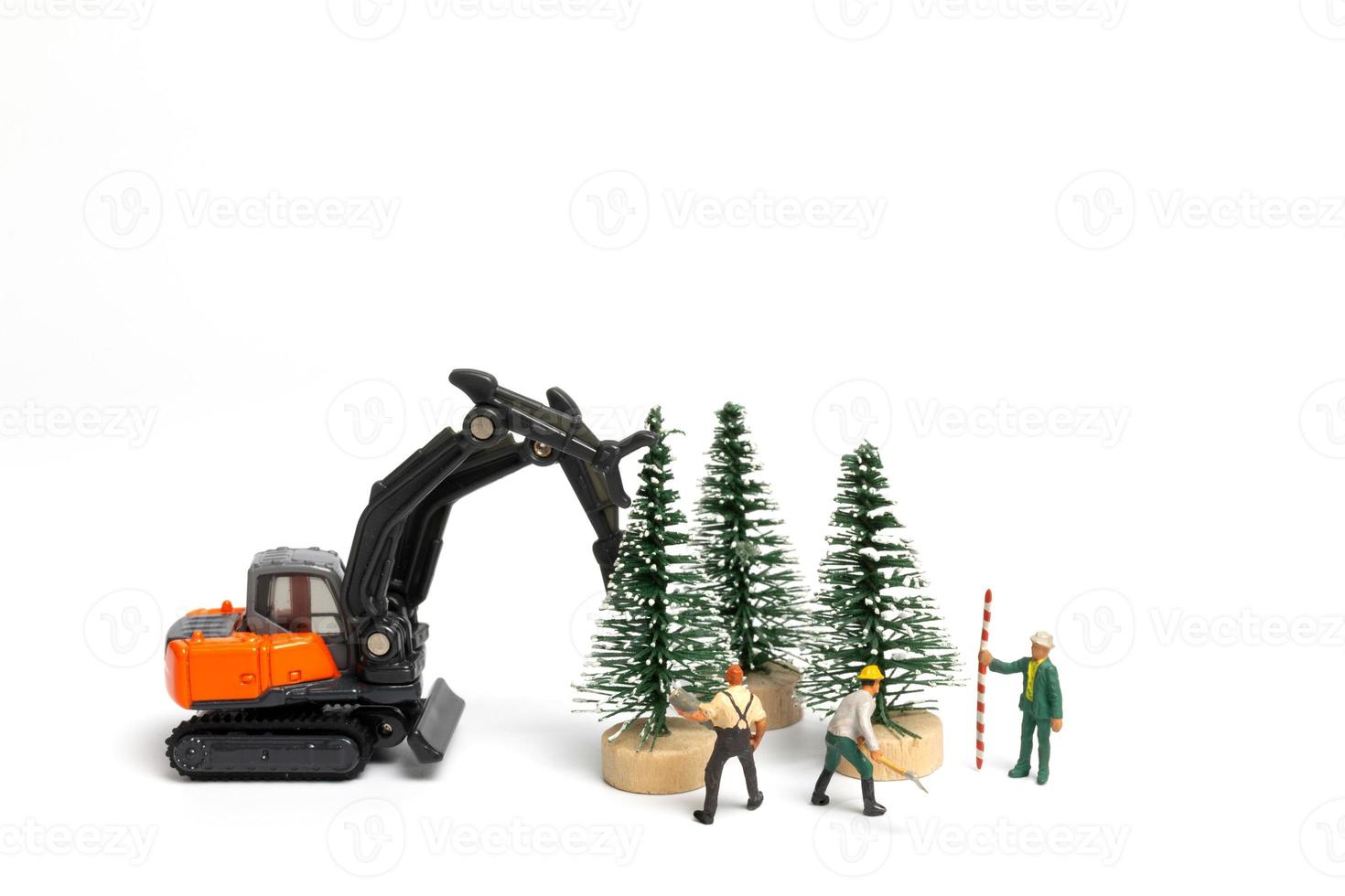 miniatuurmensen, arbeider die kerstboom op witte achtergrond voorbereiden foto