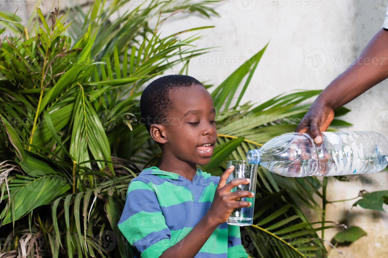 lachende kleine jongen en glas water. foto