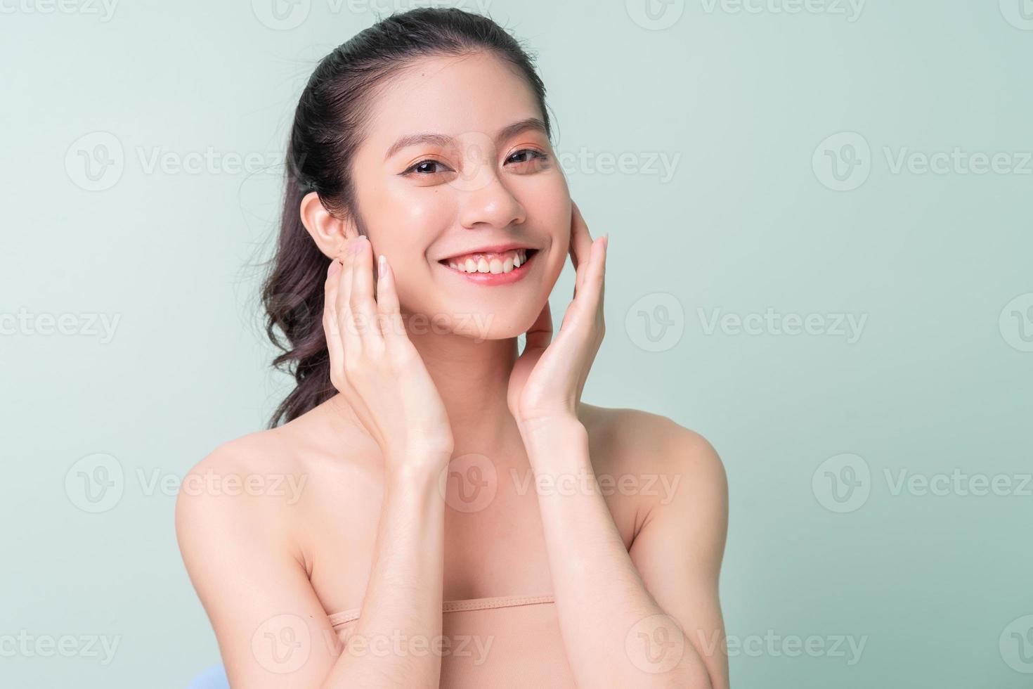 mooie jonge Aziatische vrouw met frisse huid. gezichtsverzorging, gezichtsbehandeling, vrouw schoonheid huid geïsoleerd op groene achtergrond. cosmetologie, schoonheidshuid en cosmetica foto