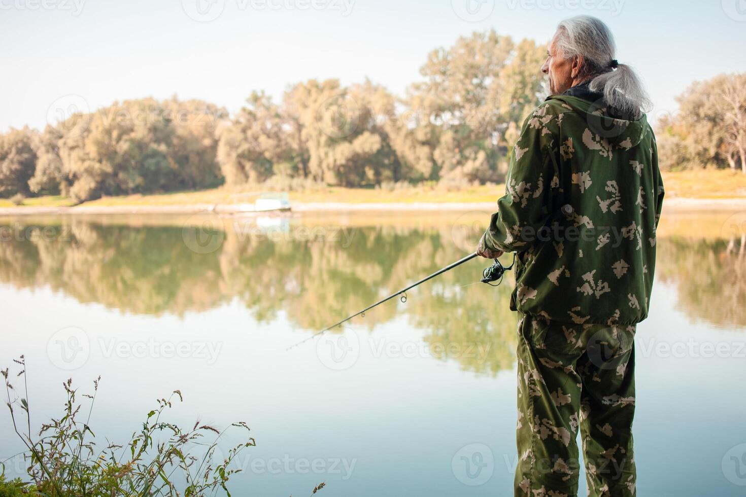 senior concept. gepensioneerde vissen Aan de rivier- in zijn Reserve tijd. een nuttig hobby, buitenshuis activiteiten in oud leeftijd. kopiëren ruimte. foto