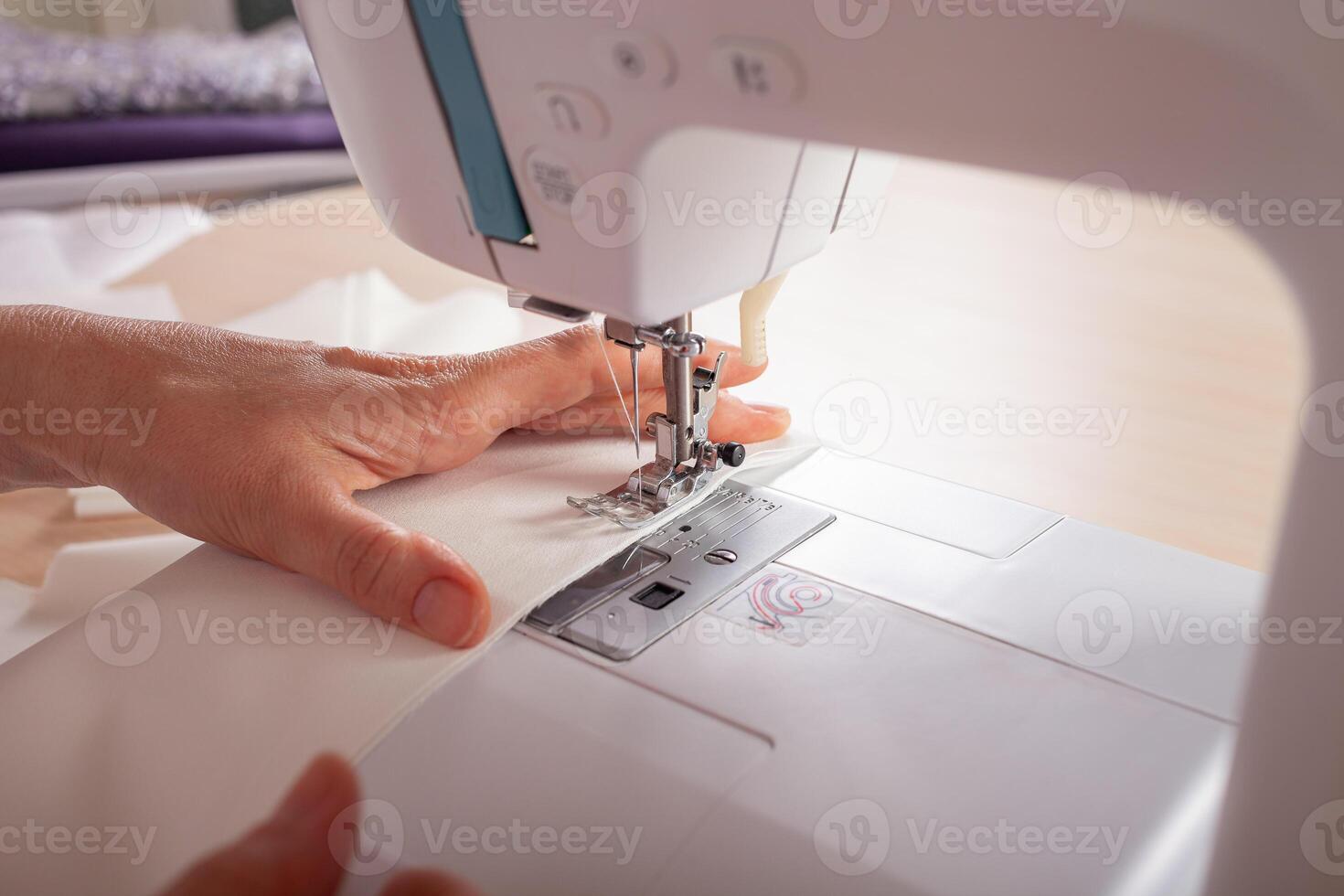 naaister Bij werk. naaister maken kleren in modern studio. kleermaker Holding potlood en markering kleding stof. vrouw staand Bij tafel met besnoeiing textiel, naaien machine, draad, pinnen, naalden, plakband, uitsparingen foto