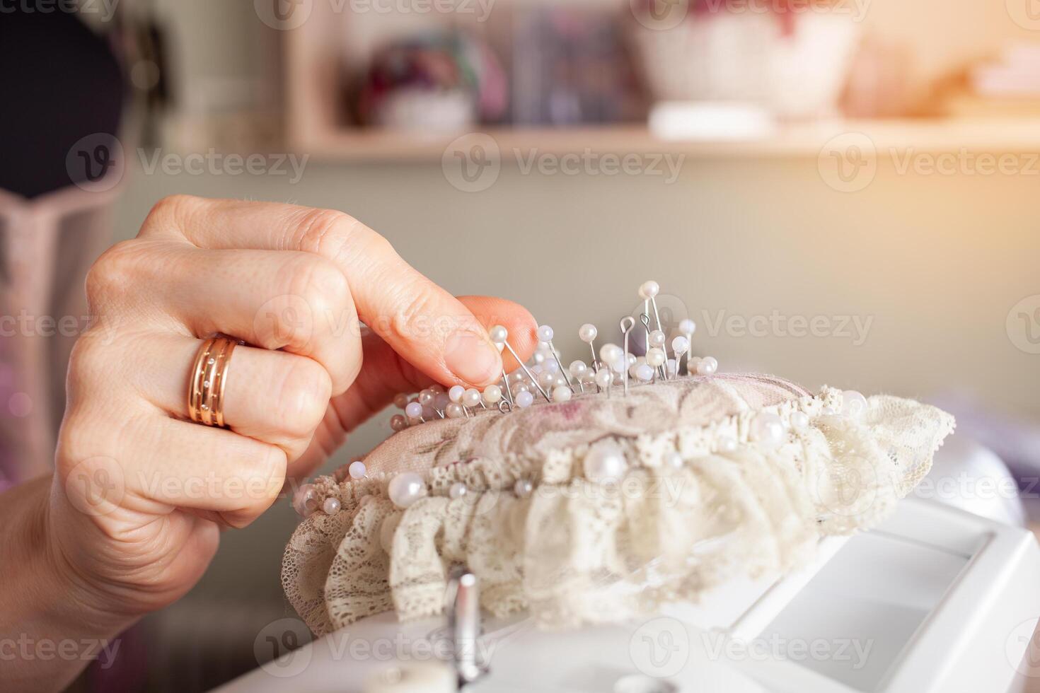 naaister Bij werk. naaister maken kleren in modern studio. kleermaker Holding potlood en markering kleding stof. vrouw staand Bij tafel met besnoeiing textiel, naaien machine, draad, pinnen, naalden, plakband, uitsparingen foto