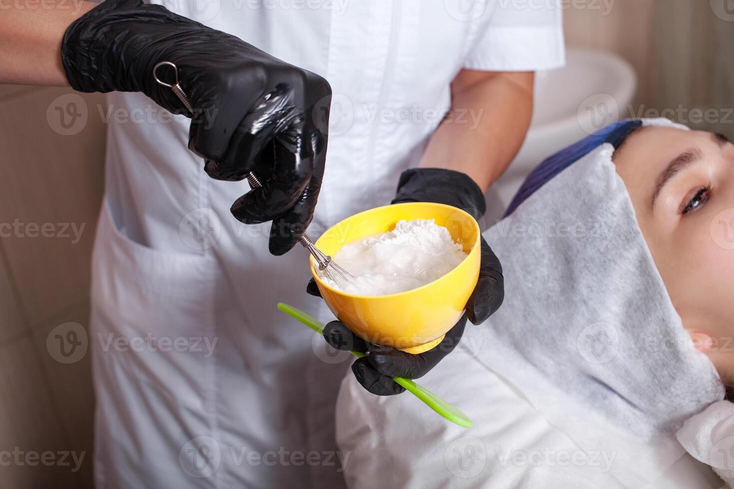 de schoonheidsspecialist maakt een alginiet masker in de schoonheid salon foto