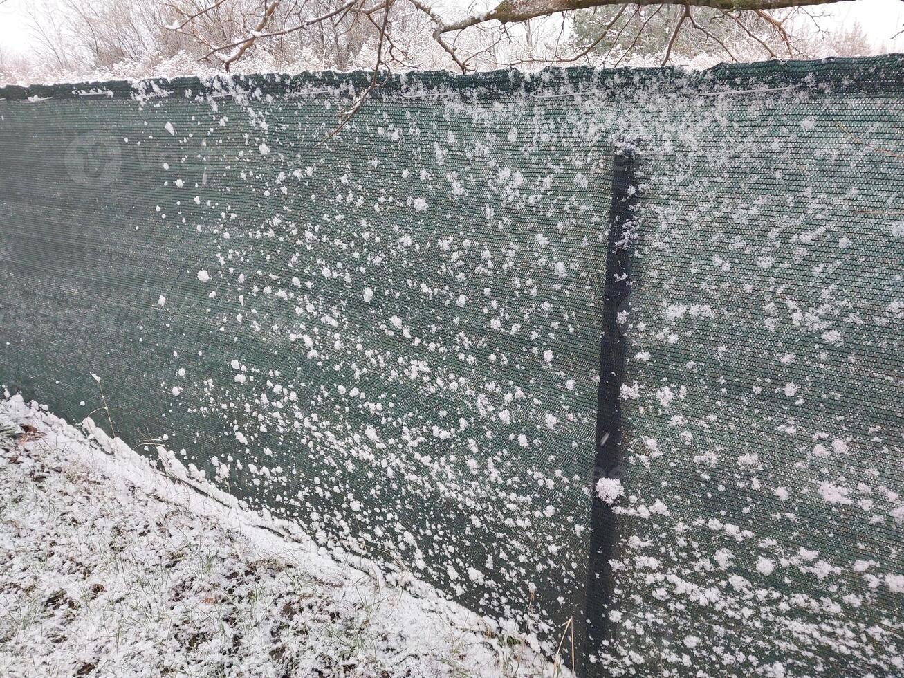 sneeuw viel Aan de hek in de dorp foto