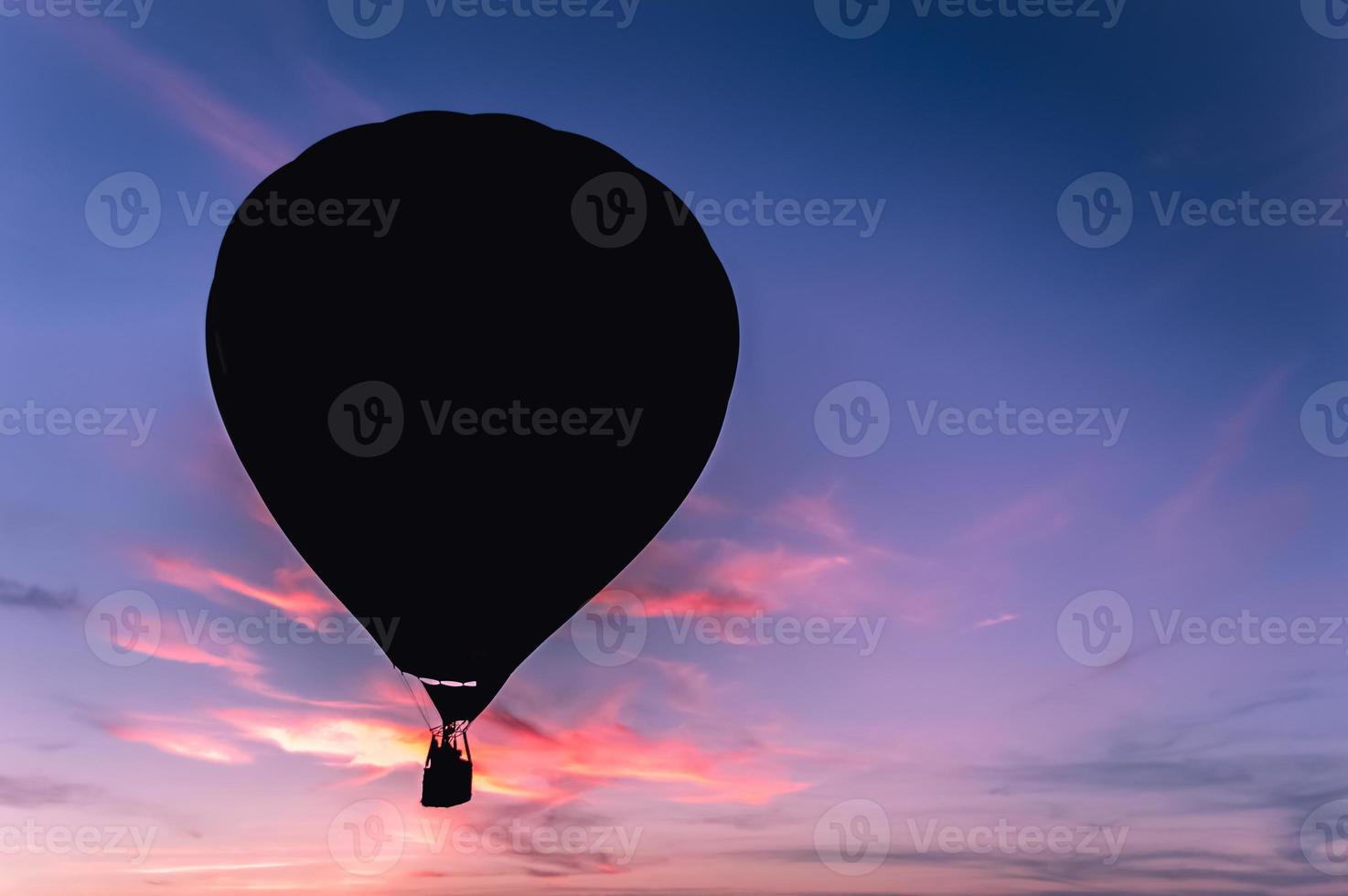 donker silhouet van hete luchtballon of aerostat op de achtergrond van kleurrijke zonsondergang foto