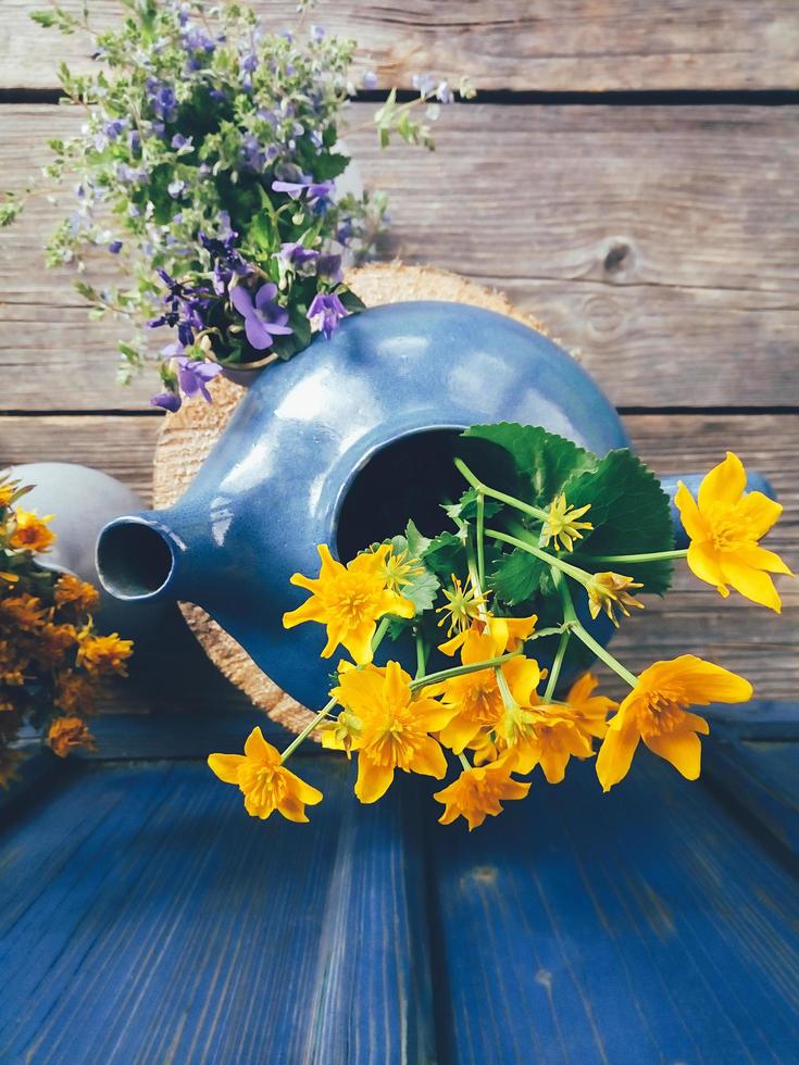 gele wilde bloemen in een blauwe pot bovenaanzicht foto